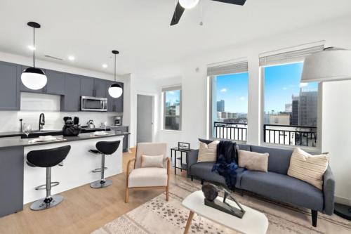a living room with a couch and a kitchen at Upscale 2BR Near Regions Field n Park in Birmingham
