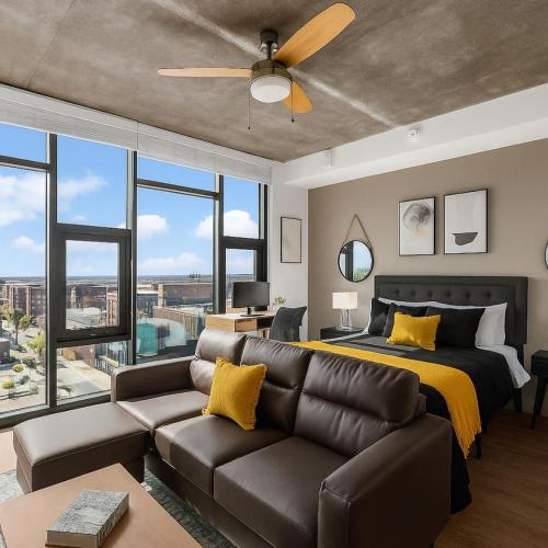 a bedroom with a couch and a bed with yellow pillows at Bright n Airy Studio Perfect City Escape 9 in Birmingham