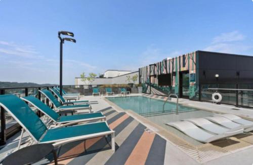 a group of lounge chairs sitting next to a swimming pool at Bright n Airy Studio Perfect City Escape 9 in Birmingham