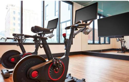 a gym with two exercise bikes and two monitors at Bright n Airy Studio Perfect City Escape 9 in Birmingham