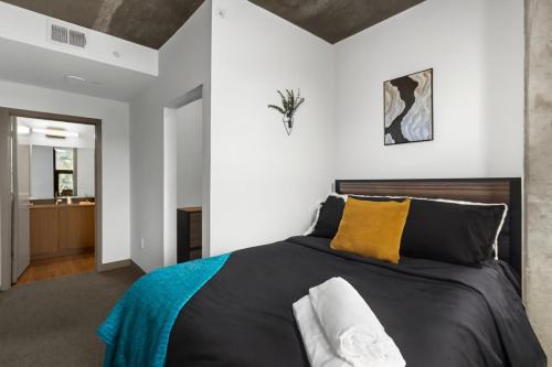 Schlafzimmer mit einem Bett mit schwarzen und gelben Kissen in der Unterkunft Prime 2BR Stay Five Points and Nightlife 7th in Birmingham