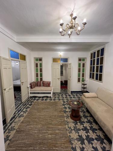 a living room with a couch and a chandelier at Dar Latifa in Fès
