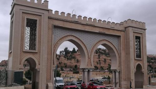 a large building with arches in a parking lot at Dar Latifa in Fès
