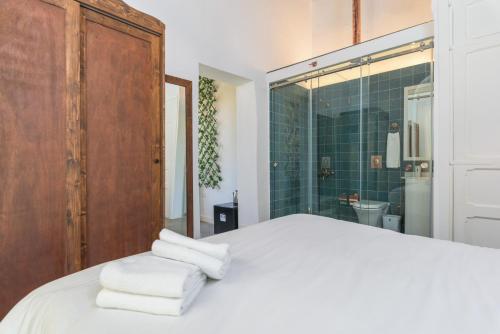 - une chambre avec un lit et une douche avec des serviettes dans l'établissement LAuberge de Douma Full House in Batroun, à Douma