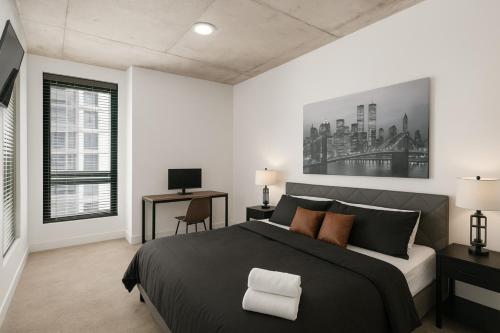 バーミングハムにあるModern 3BR Condo Five Points South Gemの大きなベッドと机のある寝室