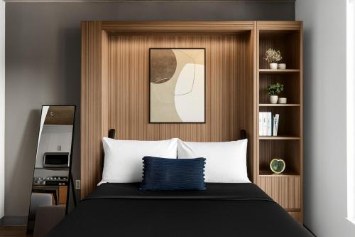 een slaapkamer met een bed met een houten hoofdeinde bij Cozy Murphy Hideaway Studio 14th in Birmingham