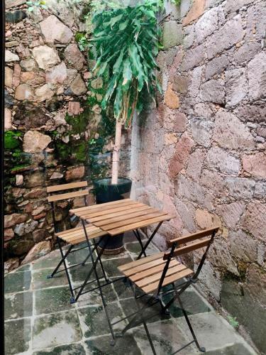 a picnic table and two chairs next to a stone wall at Hacienda Álamos in Laborcillas