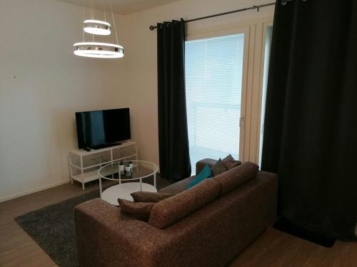 a living room with a couch and a television at Central Apartment for 2 with Sauna in Kittilä