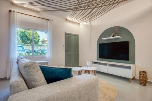 a living room with a couch and a flat screen tv at Natura Deluxe Studio & Balcony in Batroun in Ed Daourâ