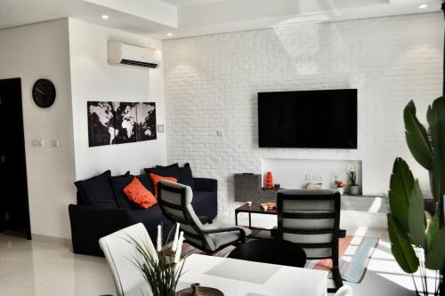 a living room with a couch and a tv at Stylish 2BR in Hawana Salalah with Beautiful Balcony in Wādī Khasbar