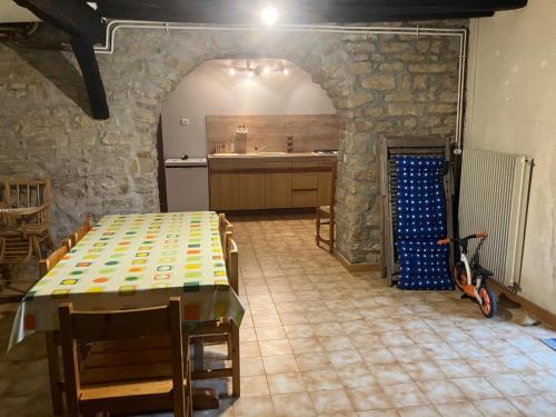 a kitchen with a table and a scooter in a room at Gîte Du Poisson Rouge in Molamboz