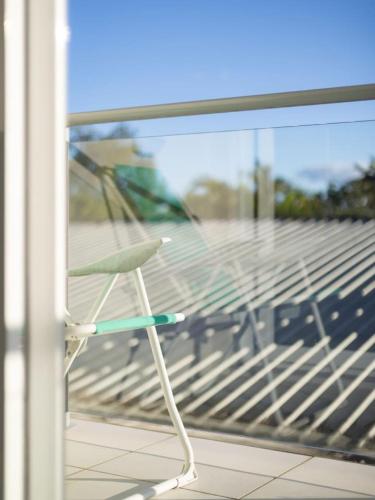 a white chair sitting on a balcony next to a window at Cozy 1BR Unit in Springwood Great Location Parking in Springwood