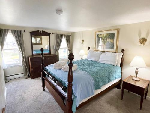 a bedroom with a bed with a green comforter at Little Miss Cottages - 173 House in Old Orchard Beach
