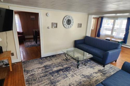 a living room with a blue couch and a glass coffee table at Little Miss Cottages - 5 Seaview House in Old Orchard Beach