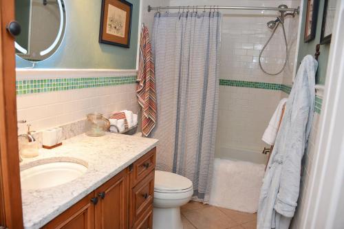 a bathroom with a sink and a toilet and a shower at Little Miss Cottages - 68 East Grand Luxury Condo in Old Orchard Beach