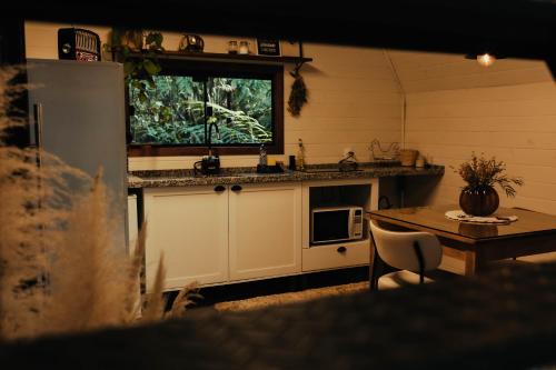 a kitchen with a table and a sink and a window at Cabana na Serra Rs in São Francisco de Paula