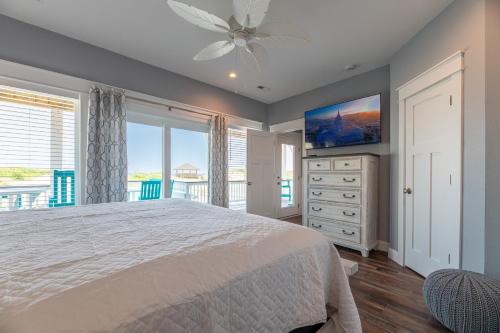 a bedroom with a large bed and a television at Salty Sunrise - K1224 in Whalebone
