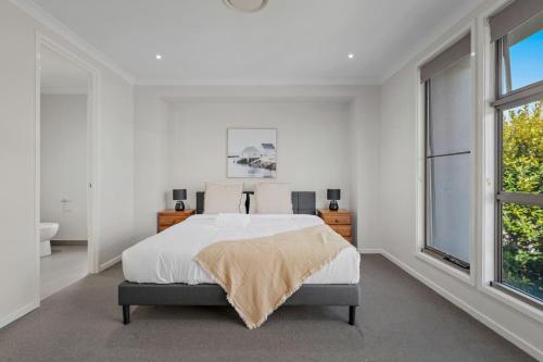 a white bedroom with a bed and a window at Modern Comfort Patio and Workstation with Garage in North Lakes