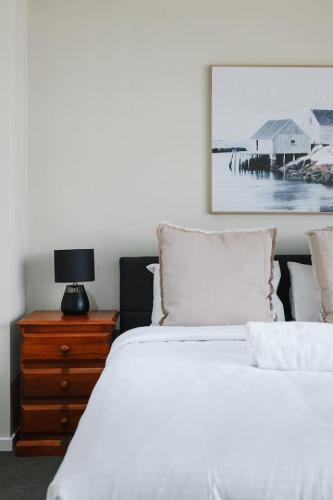 a bedroom with two beds and a dresser with a picture at Modern Comfort Patio and Workstation with Garage in North Lakes