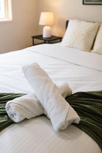 a pile of towels sitting on top of a bed at Spacious 4BR Family Home in Capalaba Local Charm in Capalaba