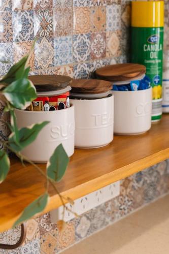 a shelf with three pots on top of it at Spacious 4BR Family Home in Capalaba Local Charm in Capalaba