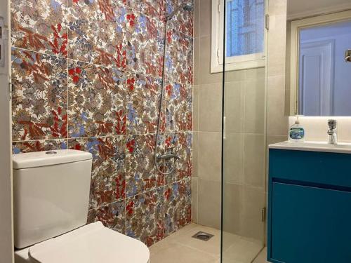 a bathroom with a toilet and a mosaic tile wall at Lester 4-Bedroom Apartment in Mar Mikhael in Al Mudawwar