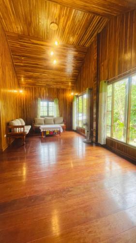 a large living room with wooden floors and a couch at Baan Sangchan in Ko Kood