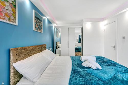 a bedroom with blue walls and a bed with two white pillows at Aspen Close 4 Bedroom Retreat with Spa, Sauna and Gym in Buckinghamshire
