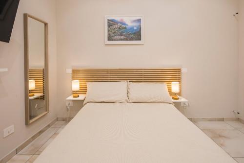 a bedroom with a large white bed with two tables at B&B al Corso in Pagani
