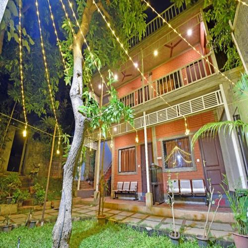 a house with a tree in front of it at Aurobay Resorts Pondicherry in Auroville