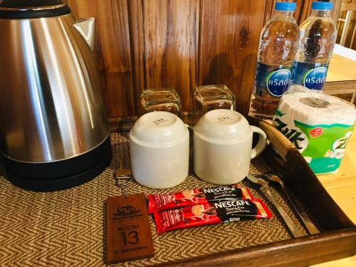 a counter with a coffee pot and cups and drinks at Baan Sangchan in Ko Kood