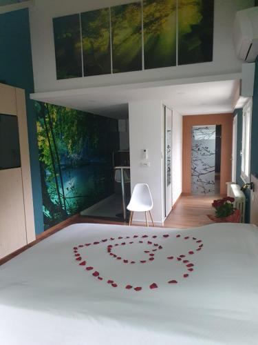 a bedroom with a white bed with a red heart rug on it at LES CLEFS DU PARADIS avec SPA in Montferrand-le-Château
