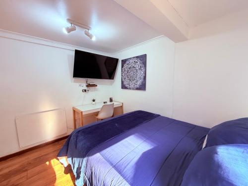 a bedroom with a bed and a desk and a tv at MAKTVB Costanera - Hostal Boutique in Santiago