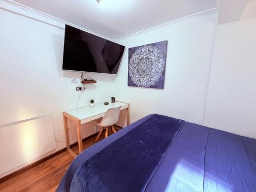 a bedroom with a bed and a desk and a tv at MAKTVB Costanera - Hostal Boutique in Santiago