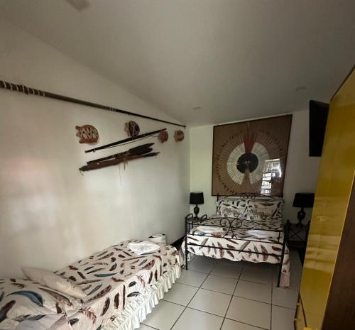 a bedroom with two beds and a mirror on the wall at Flor de Limão Hotel Boutique in Coroa Vermelha