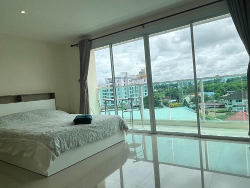 a bedroom with a bed and a large window at Bangsaray Beach B619 บางเสร่ บีช รายเดือน in Bang Sare