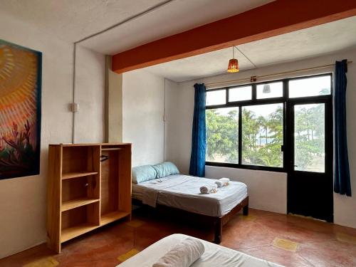 a room with two beds and a window at Hotel Manava in Brisas de Zicatela