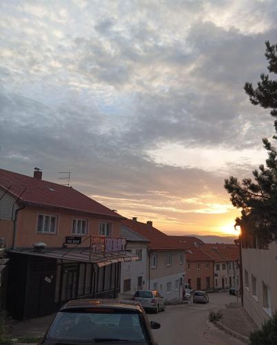 a car parked in a street with a sunset in the background at Apartman Dream in Livno