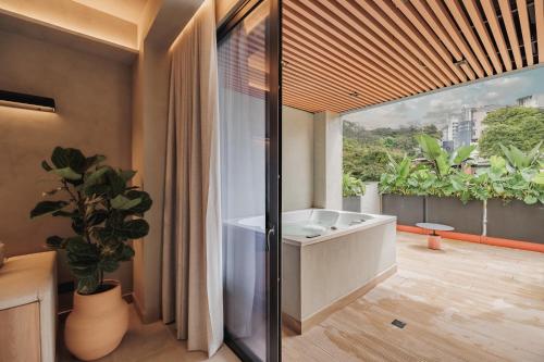 a bathroom with a tub and a large window at Kuuna Luxury Stays by Wynwood House in Medellín