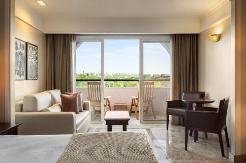 a hotel room with a bed and a living room at The Signature Level at Grand Palladium Imbassaí Resort & Spa in Imbassai