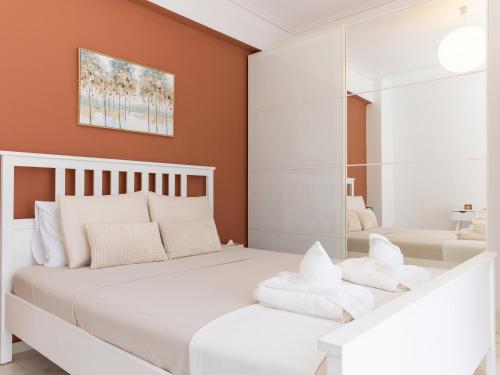 a bedroom with a white bed and a mirror at Dolce Far Niente Suite in Kalamata