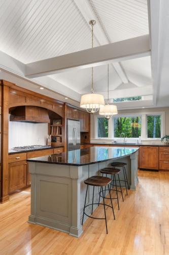 a kitchen with a large island with bar stools at Woodland Hollow in Minnetonka