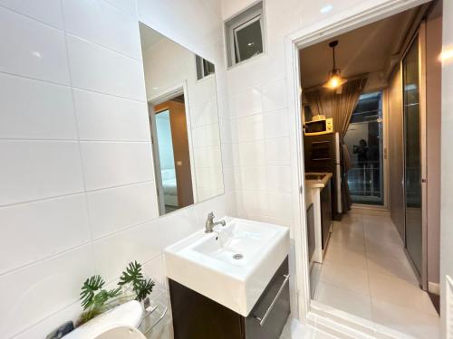 a white bathroom with a sink and a mirror at Secret Homey ห้องลับโฮมมี่ รับกุญแจที่ Pick up Key Bkk39 Airport hotel in Sathani Lat Krabang