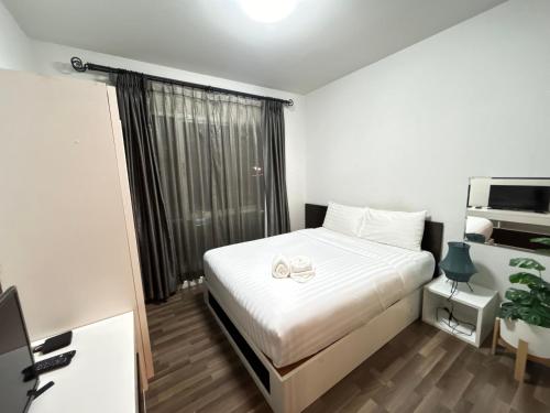 a bedroom with a white bed and a window at Secret Homey ห้องลับโฮมมี่ รับกุญแจที่ Pick up Key Bkk39 Airport hotel in Sathani Lat Krabang