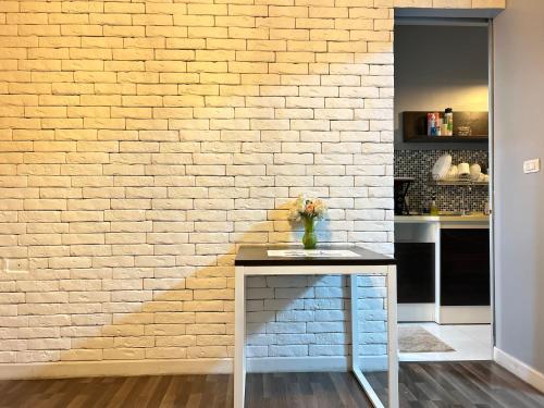 a brick wall with a table in front of it at Secret Homey ห้องลับโฮมมี่ รับกุญแจที่ Pick up Key Bkk39 Airport hotel in Sathani Lat Krabang