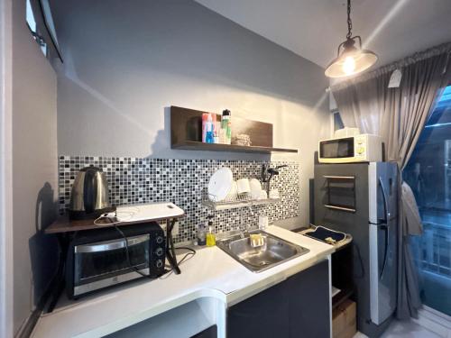 a small kitchen with a sink and a refrigerator at Secret Homey ห้องลับโฮมมี่ รับกุญแจที่ Pick up Key Bkk39 Airport hotel in Sathani Lat Krabang