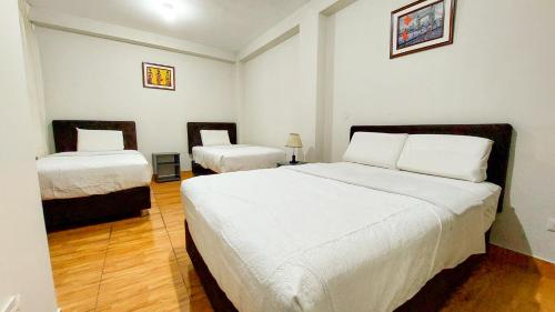 タクナにあるSamaná Hostalの部屋にベッドが2つある寝室