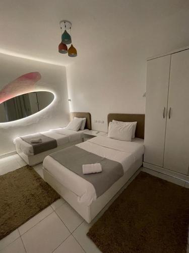 a bedroom with two beds and a mirror at Comfy Tourist Corner - Giza - Hotel Apartments in Cairo