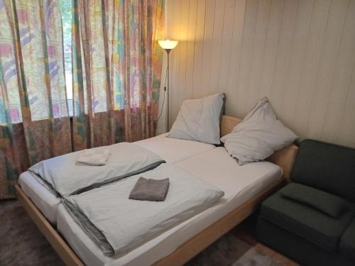 ein Bett mit einem Kissen und einem Stuhl in einem Zimmer in der Unterkunft 3 Bedroom Cozy Apartment 30min zu Hamburg in Buchholz in der Nordheide