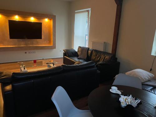a living room with leather couches and a table at Apartament an der Landgestüt in Warendorf